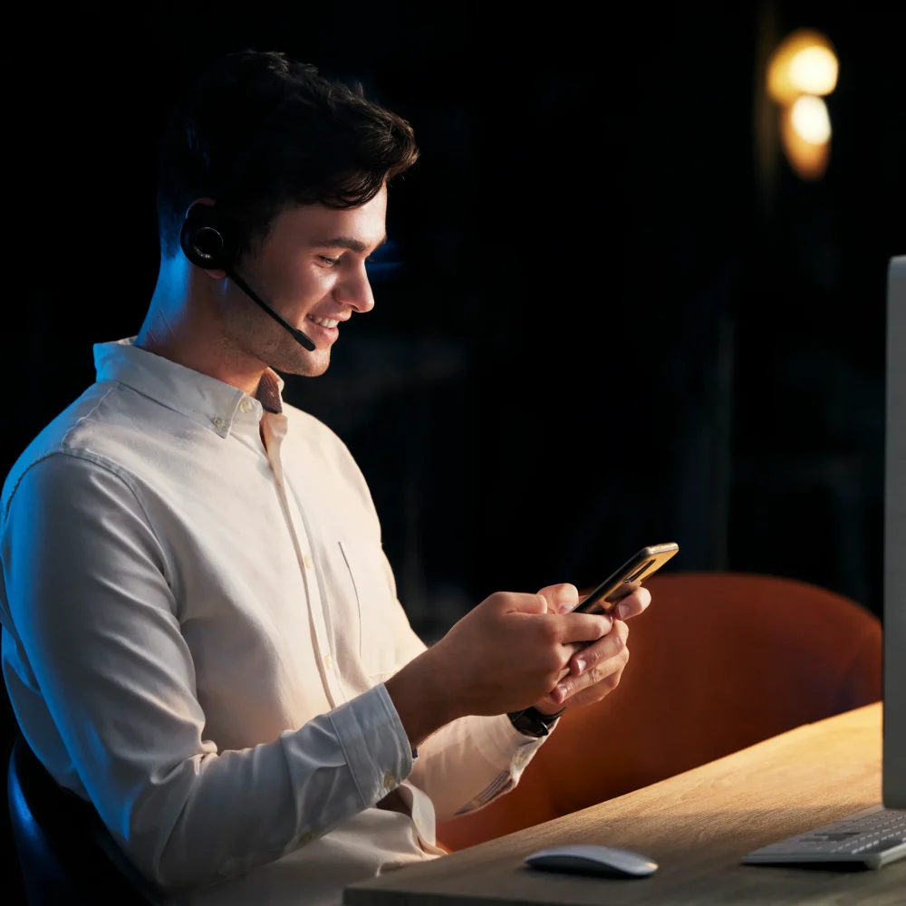 man-headphones-and-smartphone-in-office-at-night-2023-11-27-04-51-51-utc
